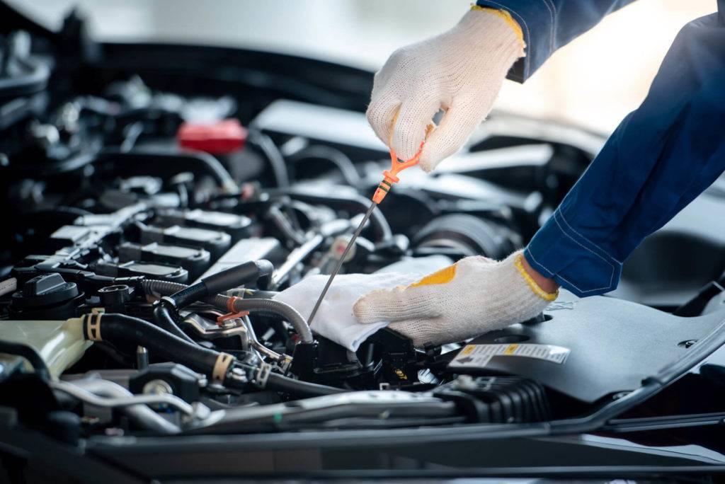 Garage service: mechanic working on car engine